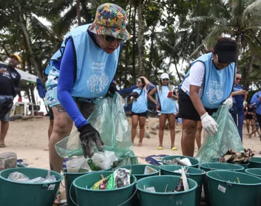 Voluntários recolhendo lixo durante limpeza da Praia de Piatã