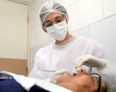 Dentista atende paciente em unidade de saúde