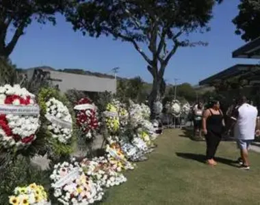 Um corredor de coroa de flores se formou no cemitério