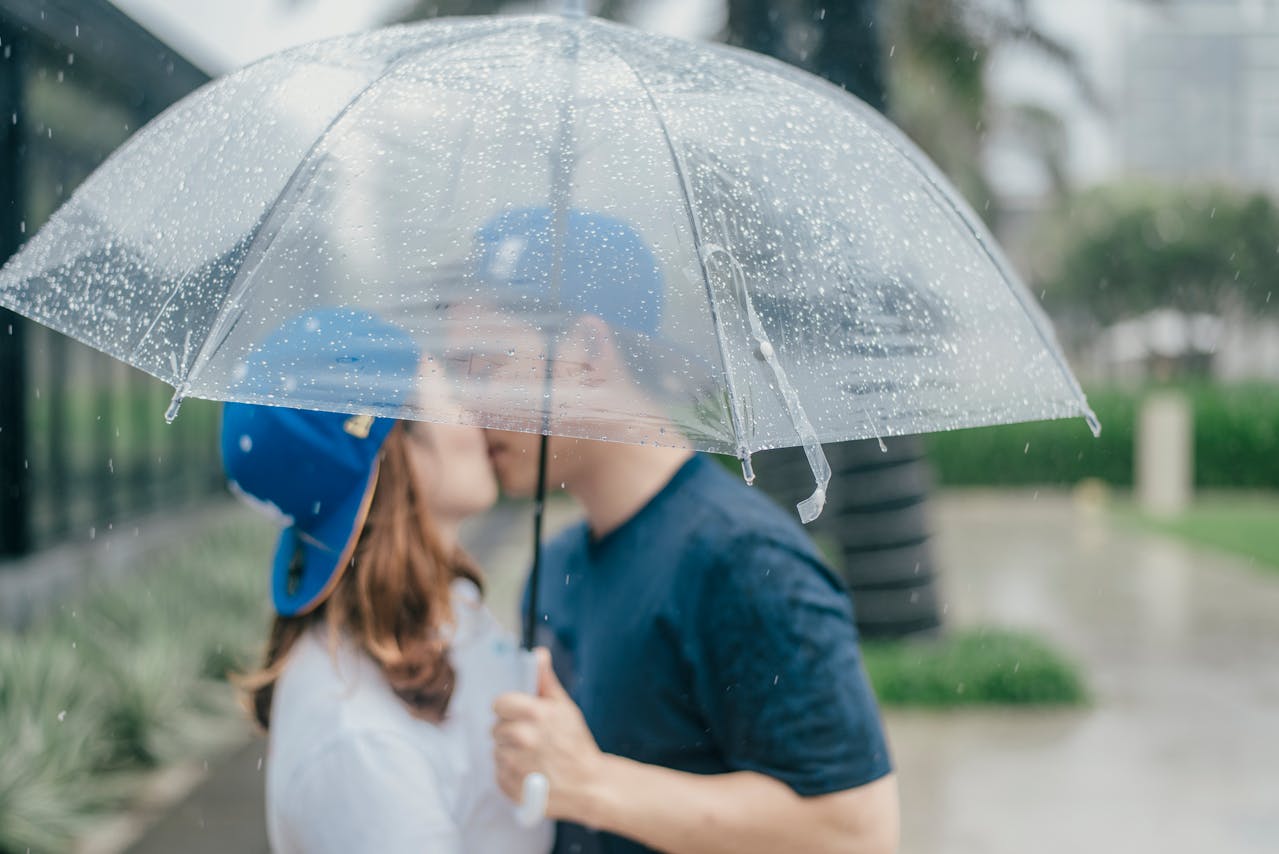 Foto ilustrativa de casal se beijando na chuva