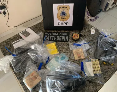 Pistola 9 mm, 58 munições, três celulares, uma câmera de videomonitoramento e uma quantia em dinheiro foram apreendidos