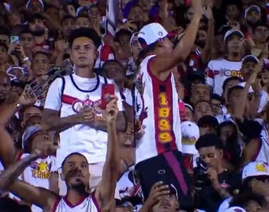 Matheuzinho assiste jogo do Vitória na arquibancada, com a torcida