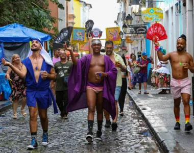 Amigos usam leques carnavalescos para driblar a chuva