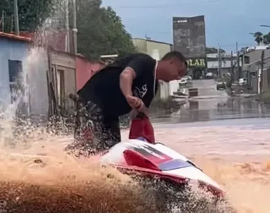 Homem anda de jet ski em rua alagada na cidade de Planaltina (GO)