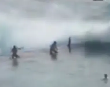 Momento em que turistas são arrastados por onda