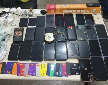 Material apreendido pela polícia inclui diversos celulares e cartões bancários