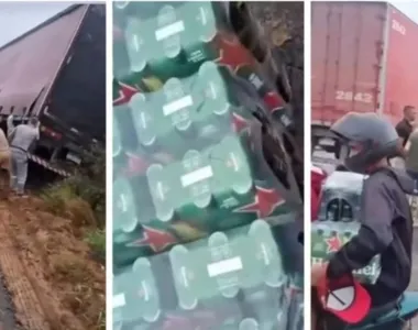 Várias pessoas carregando a bebida enquanto o caminhão permanecia tombado no acostamento
