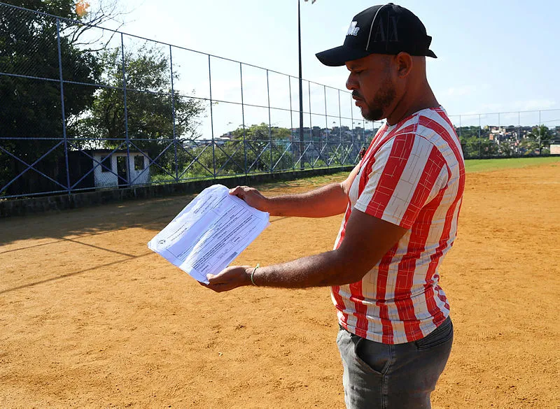 Morador mostra  documento da prefeitura onde consta a denuncia feita pelo morador constando como irregular as construções no campo do Águia