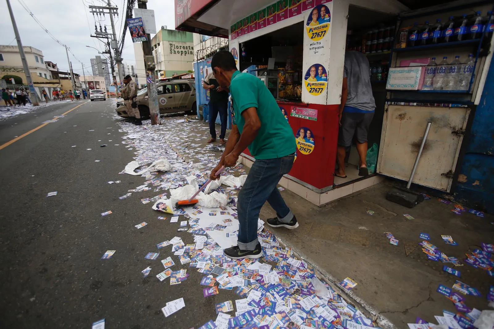 Comerciante limpa porta de colégio, tomada por santinhos