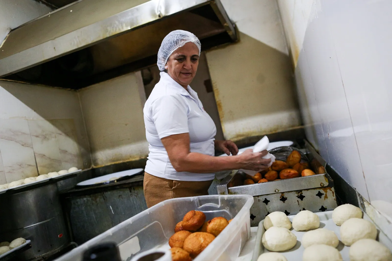 Dona Cida tem uma equipe, mas não abre mão de fritar seus quitutes