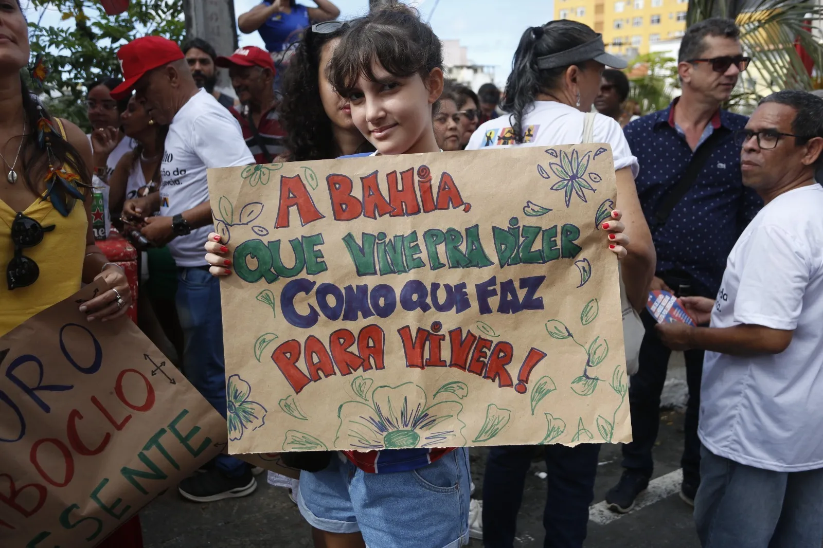 Criança usa cartaz para celebrar a Bahia