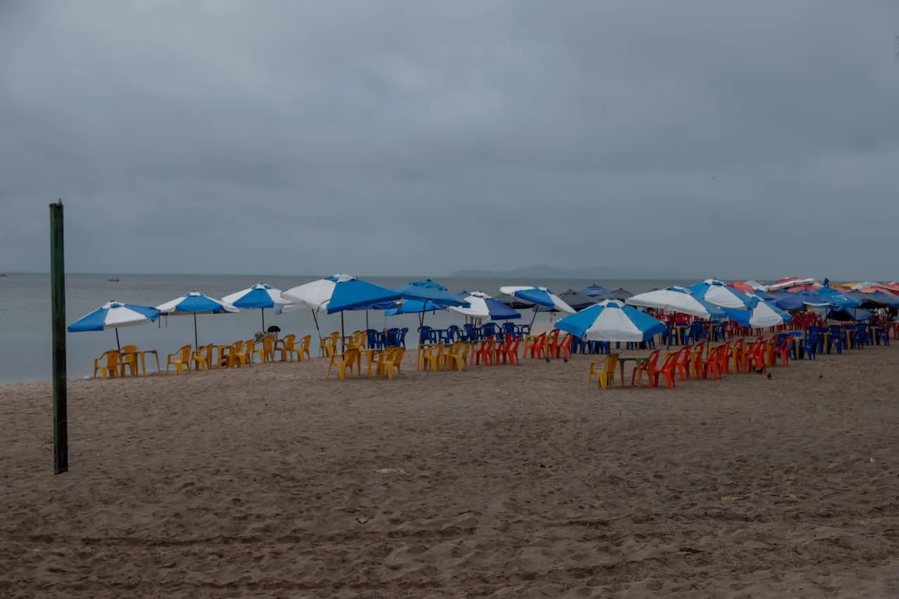 Mesas, cadeiras e guarda-sóis montados na Praia da Ribeira