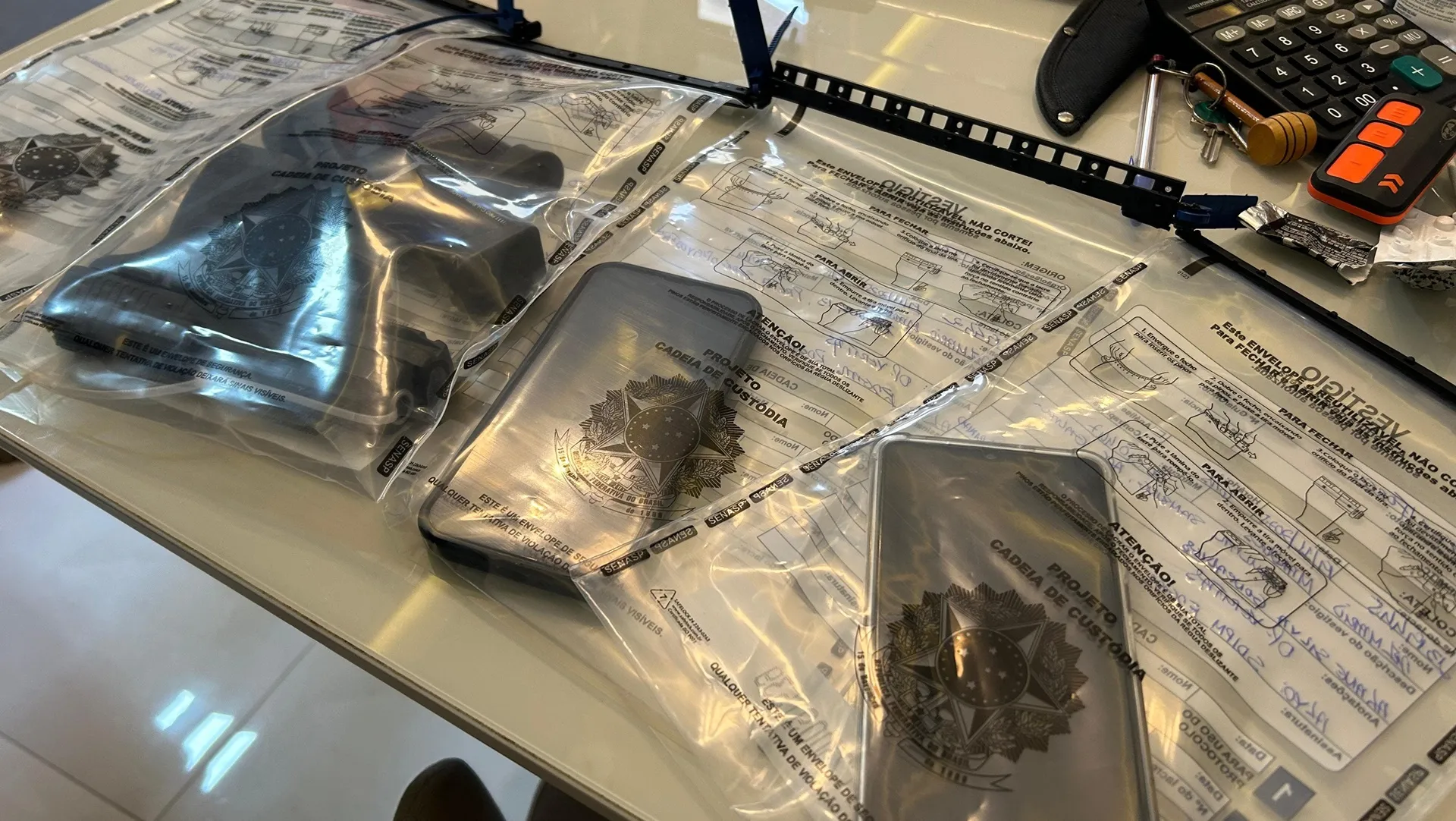 Celulares e arma apreendidos