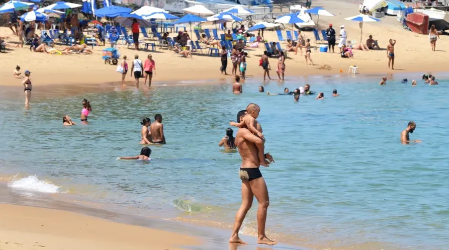 Pai e filho tomam banho no Porto da Barra, em Salvador