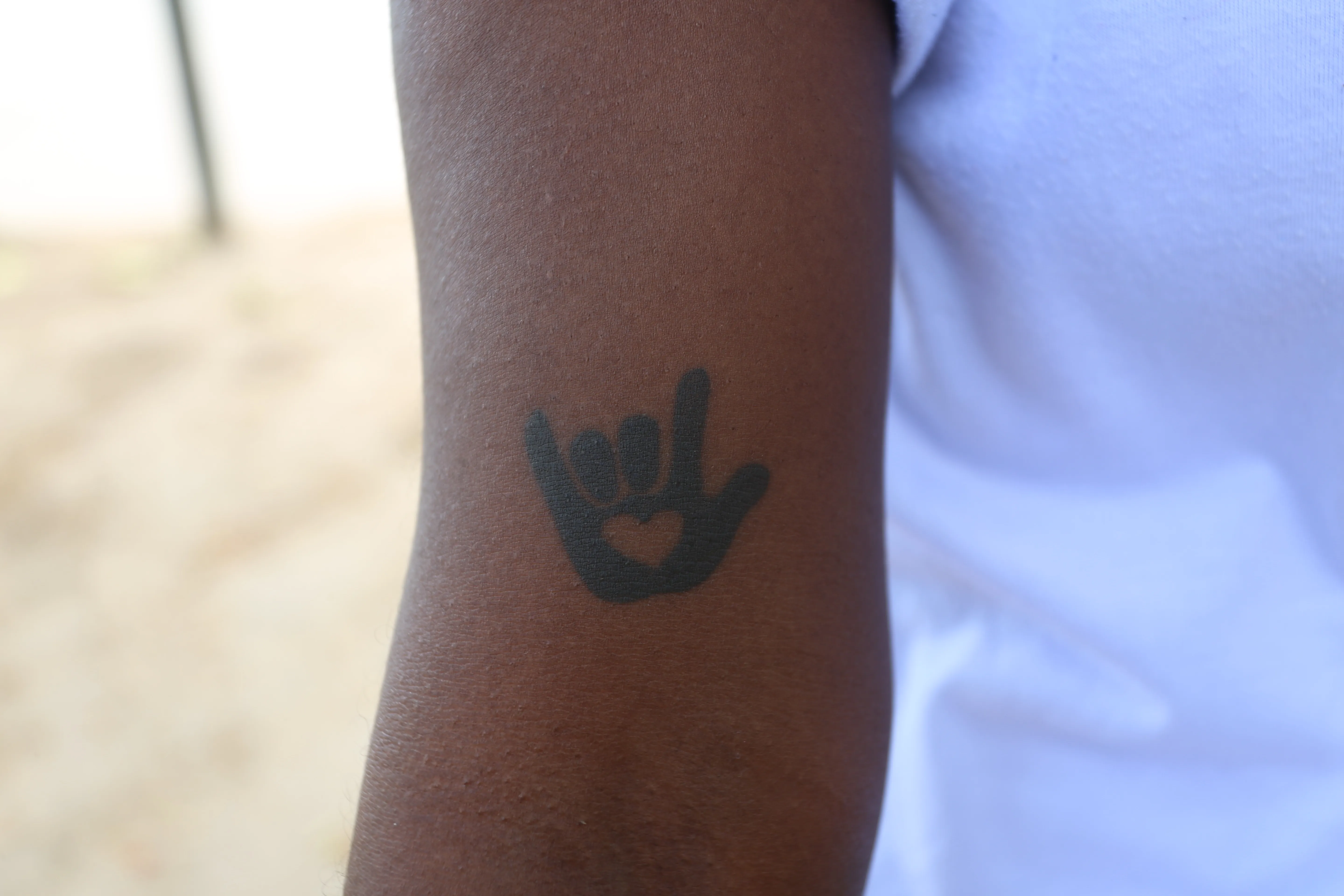 Símbolo de libras tatuado na pele